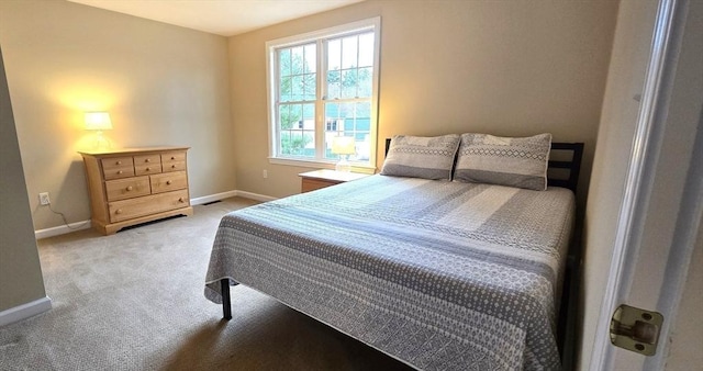 bedroom featuring light colored carpet and baseboards