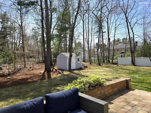 view of yard with a patio, fence, an outdoor structure, and a storage shed