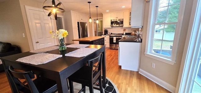 dining area with baseboards and light wood finished floors