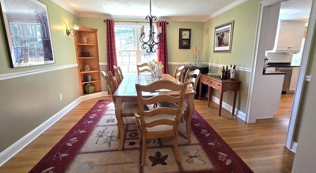 dining space featuring crown molding, wood finished floors, and baseboards
