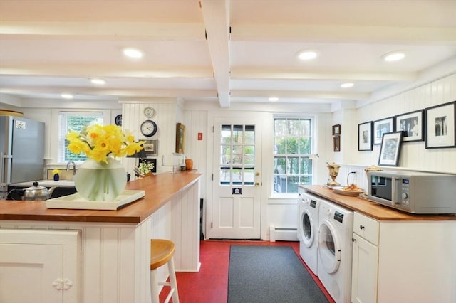 laundry room featuring separate washer and dryer, a baseboard heating unit, and sink