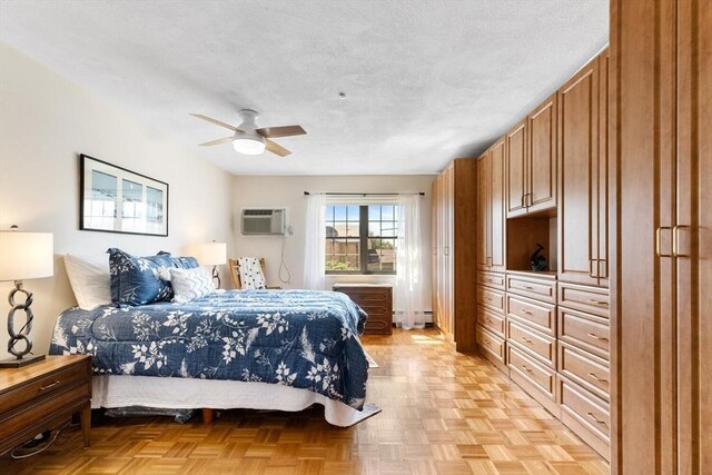 bedroom with a wall mounted air conditioner, a ceiling fan, and baseboard heating