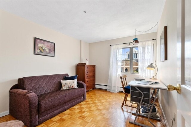 living area featuring baseboards and a baseboard heating unit