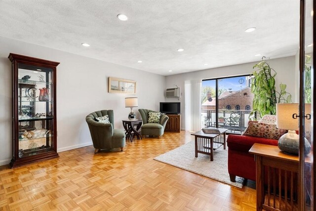 living room with baseboards, recessed lighting, and an AC wall unit