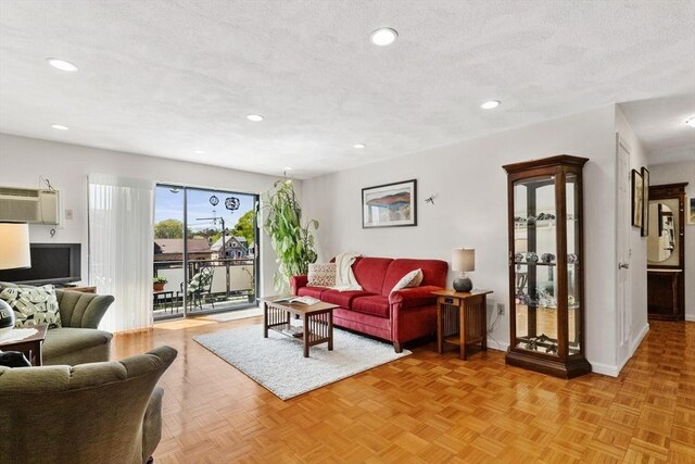 living area with recessed lighting, baseboards, and a wall unit AC