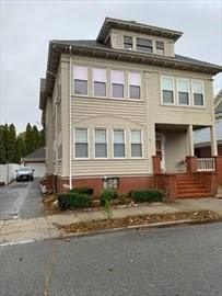 american foursquare style home featuring a porch