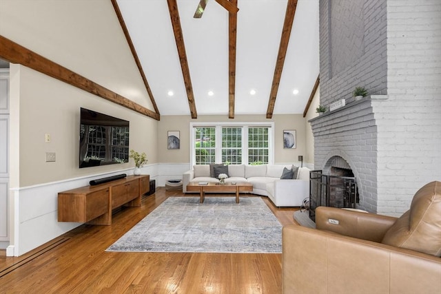 5 John Matthew Rd, Hopkinton, MA 01748 - living area with beam ceiling, a brick fireplace, wood finished floors, a wainscoted wall, and high vaulted ceiling