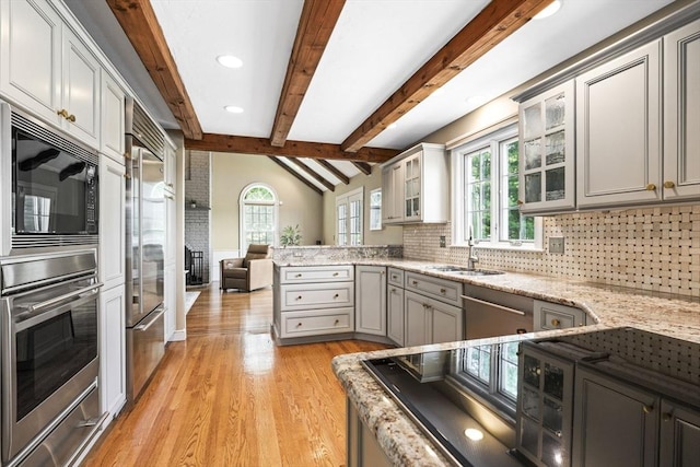 5 John Matthew Rd, Hopkinton, MA 01748 - kitchen featuring built in appliances, backsplash, light wood-style flooring, a peninsula, and healthy amount of natural light