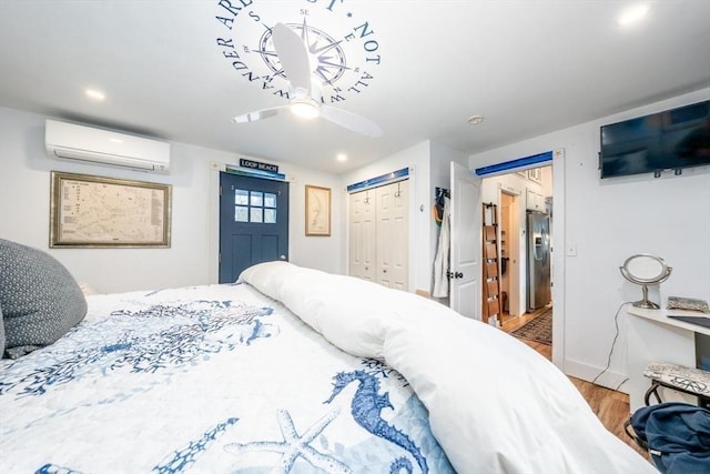 bedroom with a ceiling fan, recessed lighting, an AC wall unit, stainless steel fridge with ice dispenser, and wood finished floors