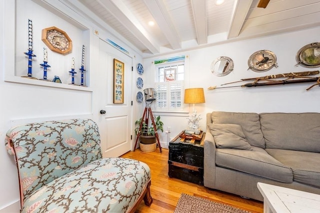 living area with beamed ceiling and wood finished floors
