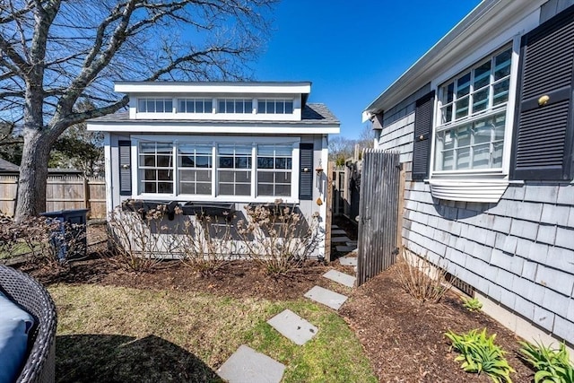 exterior space featuring fence and an outbuilding