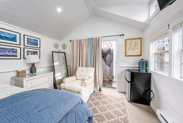 bedroom featuring freestanding refrigerator, multiple windows, vaulted ceiling, and a baseboard radiator