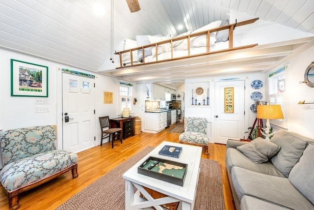 living area with lofted ceiling with beams, wood ceiling, and light wood-style floors