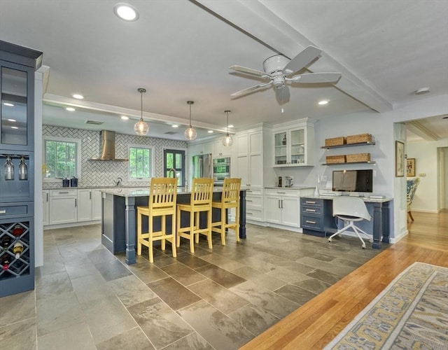 15 Blackburnian Rd, Lincoln, MA 01773 - kitchen featuring wall chimney range hood, white cabinets, a center island, ceiling fan, and recessed lighting