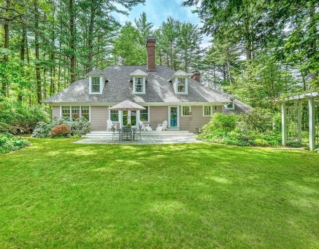 15 Blackburnian Rd, Lincoln, MA 01773 - rear view of house featuring a chimney, a lawn, a patio area, and a shingled roof