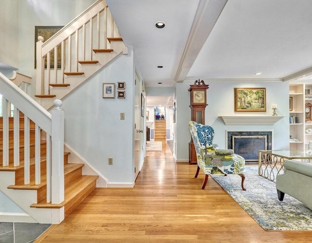 15 Blackburnian Rd, Lincoln, MA 01773 - entryway featuring light wood finished floors, stairs, a high end fireplace, baseboards, and ornamental molding