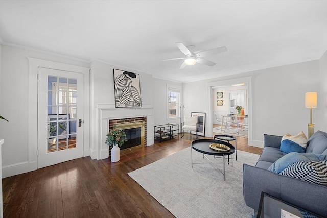 living room featuring dark wood-type flooring, a fireplace, and ceiling fan