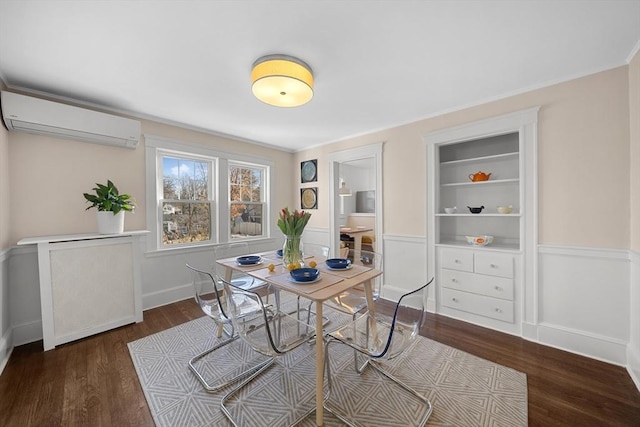 dining space with built in shelves, an AC wall unit, dark wood-type flooring, and ornamental molding