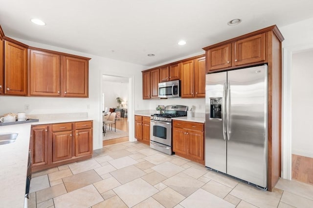 32 Old Framingham Rd Unit 20, Sudbury, MA 01776 - kitchen featuring stainless steel appliances, light countertops, brown cabinetry, and recessed lighting