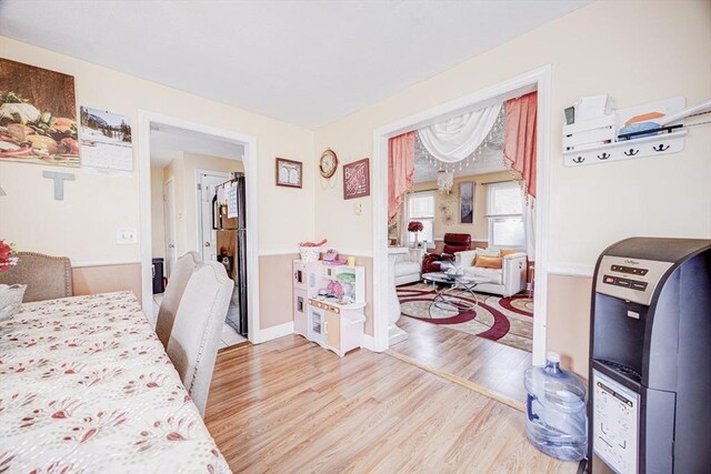 bedroom featuring freestanding refrigerator and wood finished floors