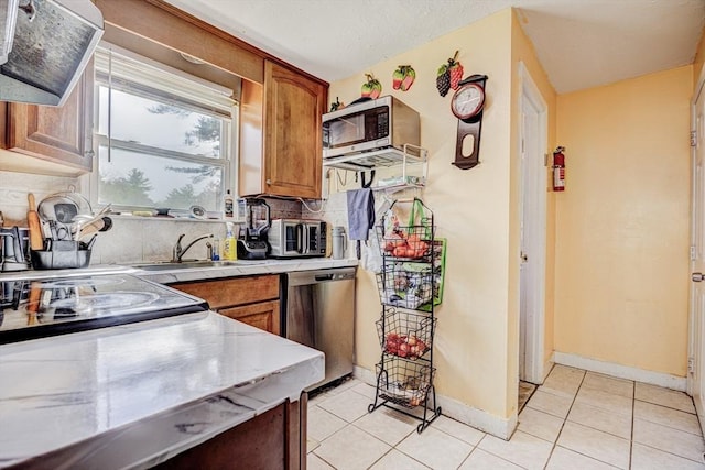 kitchen with ventilation hood, tasteful backsplash, light tile patterned flooring, and stainless steel appliances