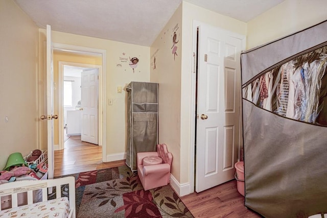 bedroom with baseboards and wood finished floors