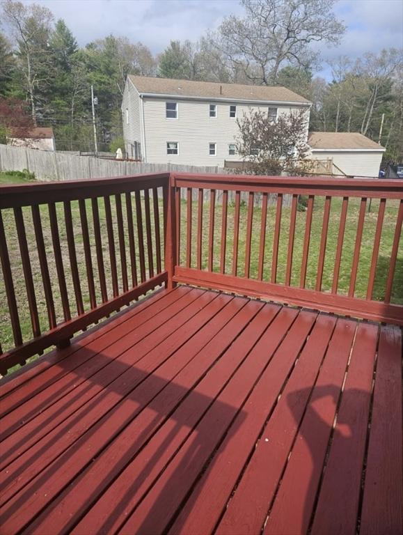 wooden deck with a fenced backyard and a yard
