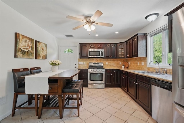 3 Birch Ave, East Longmeadow, MA 01028 - kitchen featuring appliances with stainless steel finishes, a sink, tasteful backsplash, dark brown cabinetry, and light tile patterned floors