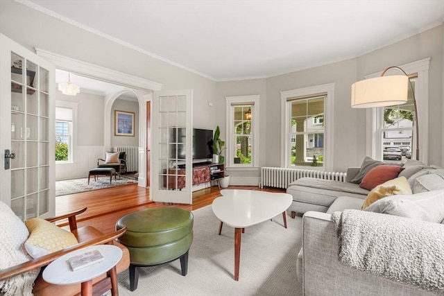 97 Manet Rd, Newton, MA 02467 - living area featuring radiator, wood finished floors, french doors, ornamental molding, and wainscoting