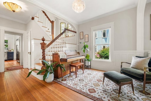 97 Manet Rd, Newton, MA 02467 - living area with wood-type flooring, stairs, plenty of natural light, crown molding, and a wainscoted wall