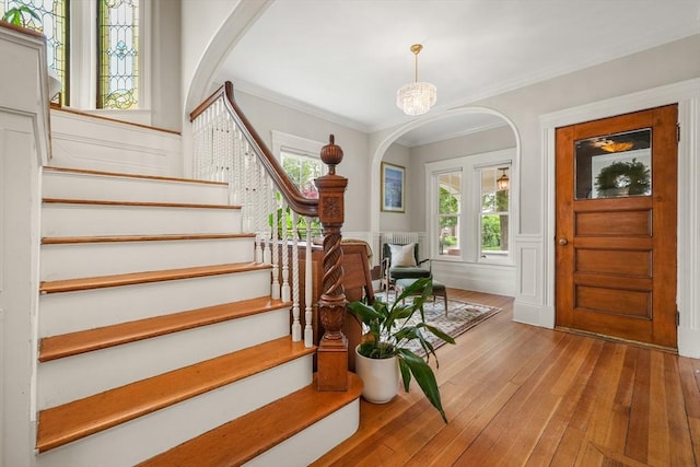 97 Manet Rd, Newton, MA 02467 - entryway featuring stairway, arched walkways, wood-type flooring, a wainscoted wall, and a decorative wall