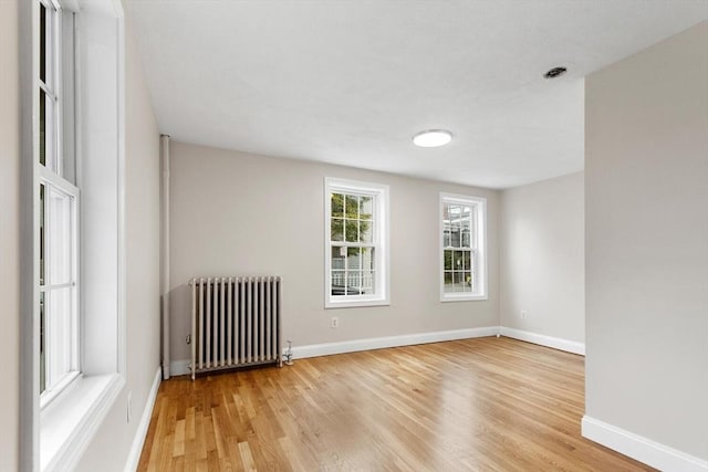 spare room with radiator and hardwood / wood-style floors