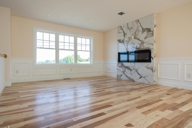 21 Seattle St, Worcester, MA 01604 - unfurnished living room featuring a decorative wall, wood finished floors, wainscoting, and a high end fireplace