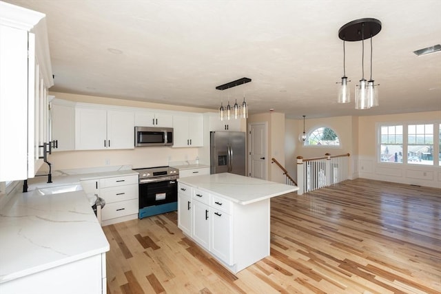 21 Seattle St, Worcester, MA 01604 - kitchen featuring stainless steel appliances, light wood-type flooring, white cabinetry, and wainscoting