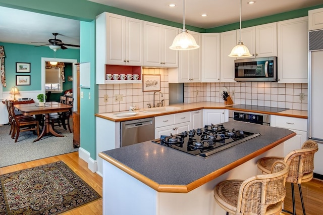 kitchen with ceiling fan, light hardwood / wood-style flooring, tasteful backsplash, and black appliances