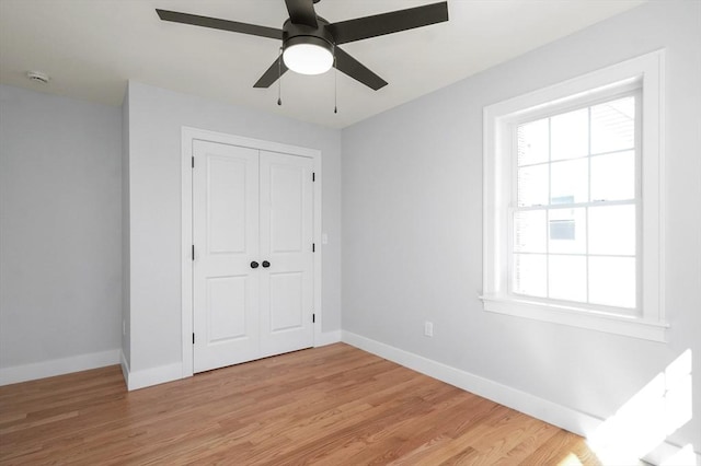 117 Montvale Ave, Woburn, MA 01801 - unfurnished bedroom featuring baseboards, light wood-style flooring, a closet, and ceiling fan