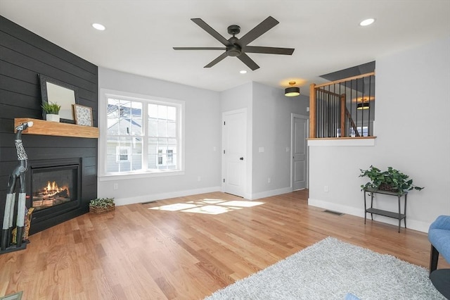 117 Montvale Ave, Woburn, MA 01801 - living room featuring a large fireplace, wood finished floors, ceiling fan, baseboards, and stairway