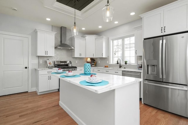 117 Montvale Ave, Woburn, MA 01801 - kitchen featuring appliances with stainless steel finishes, wall chimney range hood, a sink, white cabinets, and recessed lighting