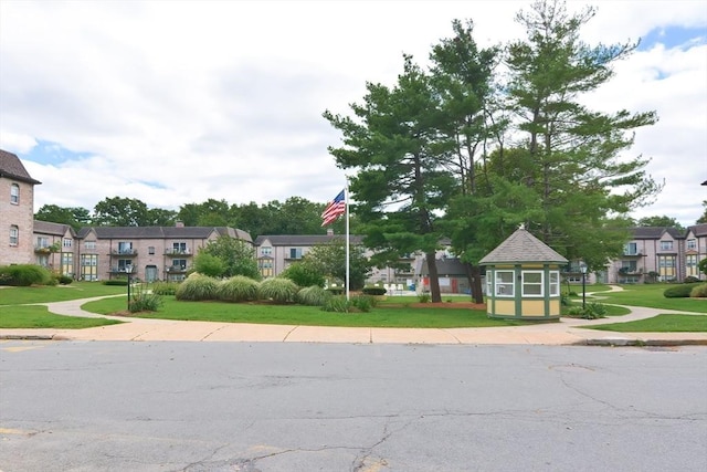 view of asphalt road with sidewalks, curbs, and a residential view