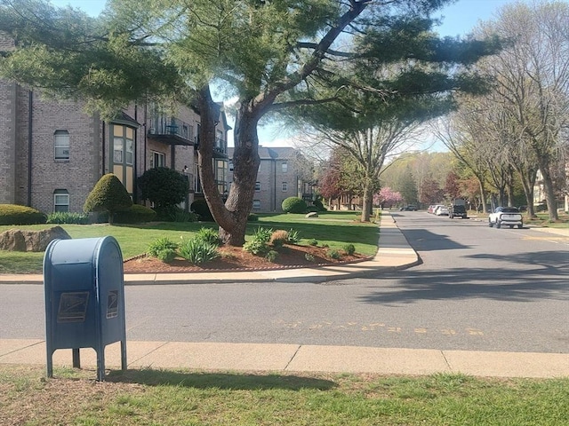 view of asphalt road with curbs and sidewalks