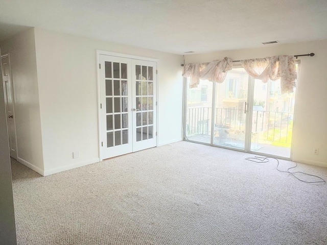 carpeted spare room with french doors and baseboards