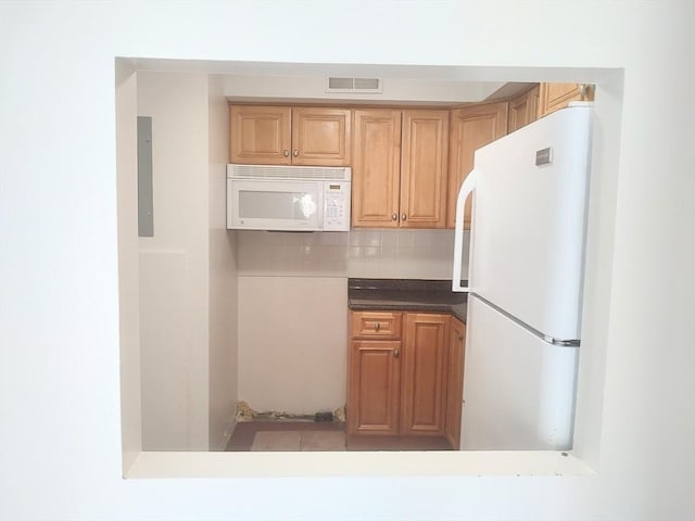 kitchen featuring white appliances, tasteful backsplash, and electric panel