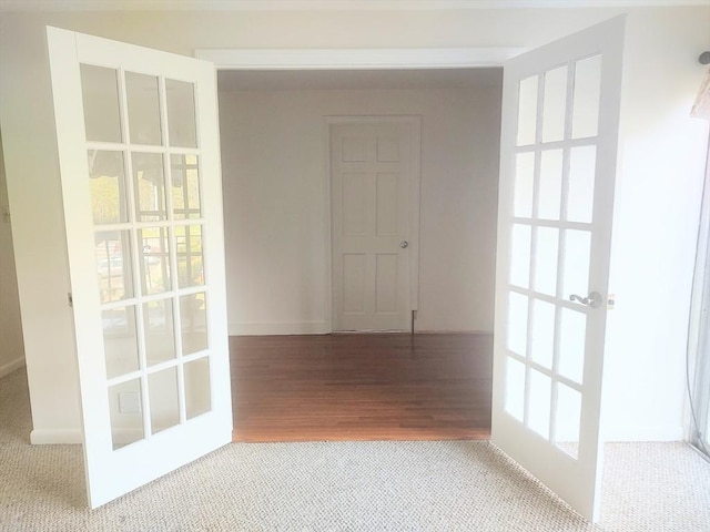 corridor featuring carpet flooring, french doors, and healthy amount of natural light