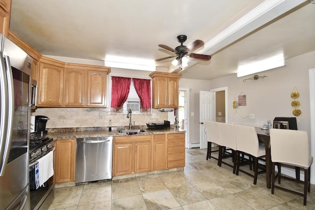 kitchen with stainless steel appliances, tasteful backsplash, a ceiling fan, baseboard heating, and a sink