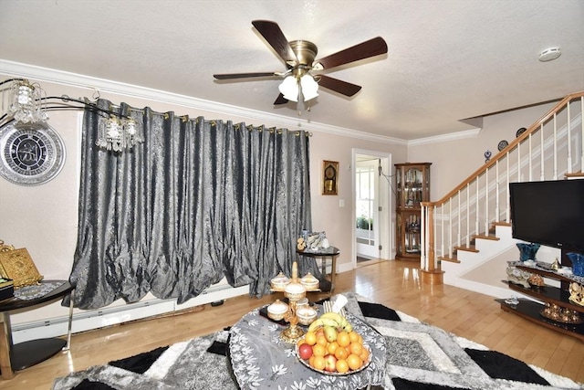 living area featuring stairs, wood finished floors, ornamental molding, a ceiling fan, and a textured ceiling