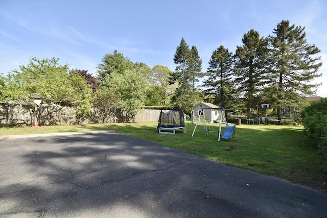view of property exterior featuring a trampoline and a playground