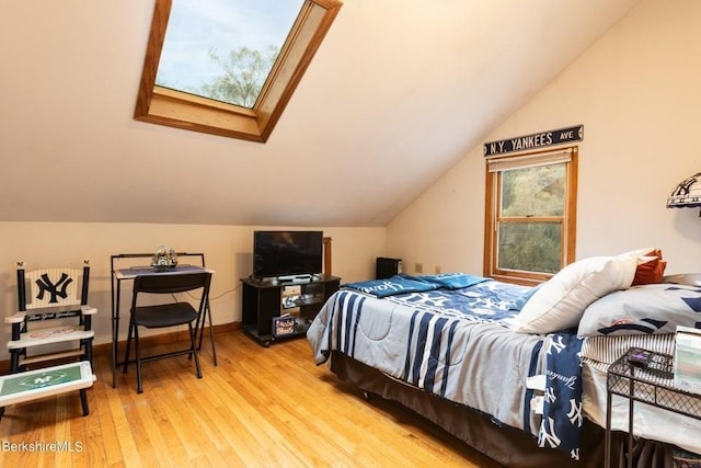 bedroom with a skylight and hardwood / wood-style flooring