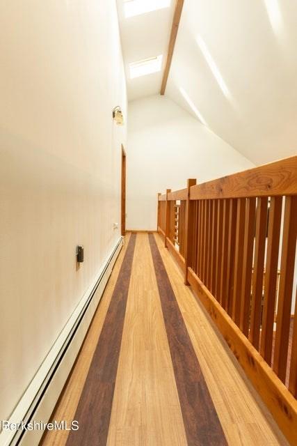 hall featuring wood-type flooring, a baseboard heating unit, and vaulted ceiling