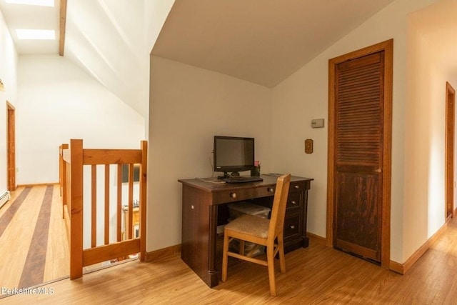 office space with light hardwood / wood-style floors and lofted ceiling