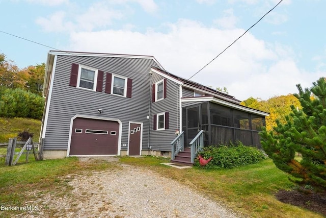 view of front facade with a garage and a sunroom